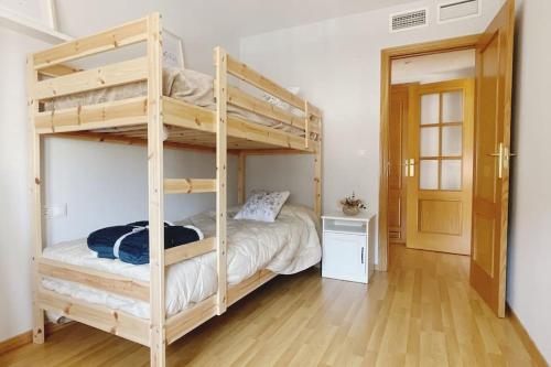 a bedroom with two bunk beds and a wooden floor at Balcón hacia la montaña in Güéjar-Sierra