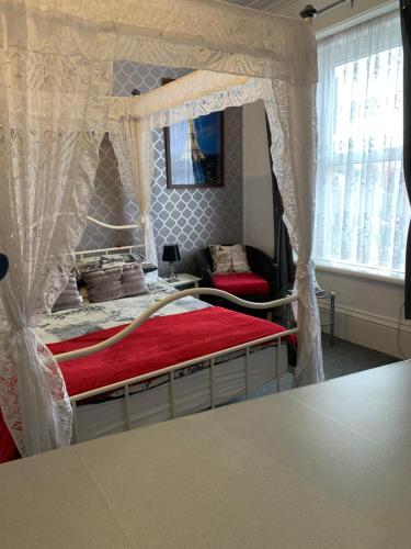 a bedroom with a canopy bed with a red mattress at Hornby Villa B&B Couples & Families Only- Quiet Central Location- Near To Winter Gardens in Blackpool