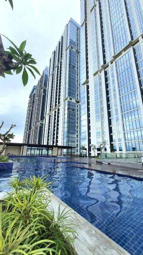 a large swimming pool in front of tall buildings at Sri Studio 07@Pollux Habibie Meisterstadt in Batam Center