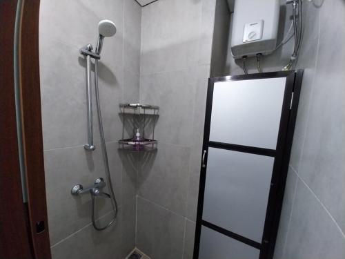 a shower with a glass door in a bathroom at Sri Studio 07@Pollux Habibie Meisterstadt in Batam Center