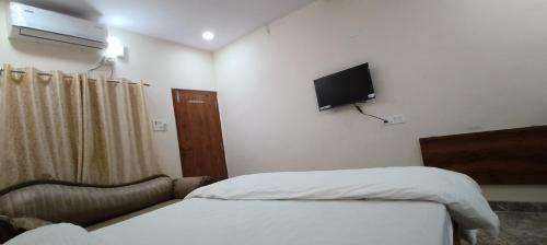 a bedroom with a bed and a tv on the wall at RK RESIDENCY in Kothakota