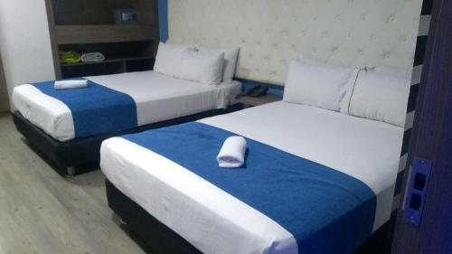 a hotel room with two beds and a pillow on it at Plaza Miranda in Bogotá