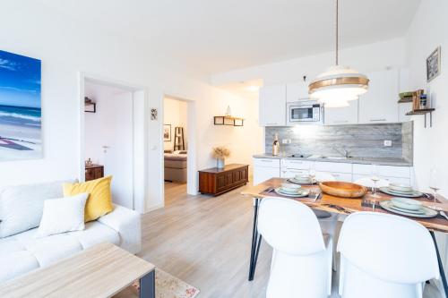 a kitchen and living room with a table and chairs at Stylische Surfoase am Wasser in Dranske