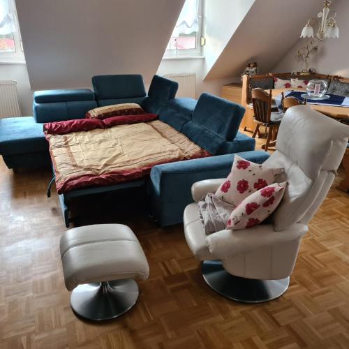 a living room with a bed and a couch and chairs at Ferienwohnung Sahrmann in Mistelgau