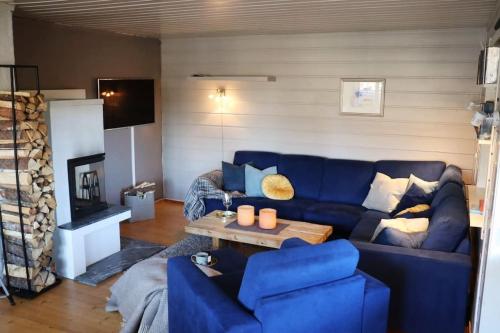 een woonkamer met een blauwe bank en een open haard bij Familiehytte på Beito in Beitostøl