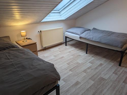 a bedroom with two beds and a skylight at Ferienwohnung Pusteblume in Marktbergel