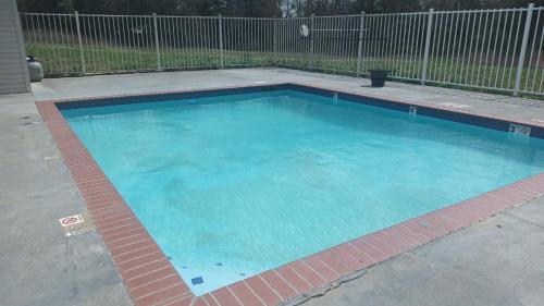 uma grande piscina com água azul num quintal em Mississippi Hotel em Macon