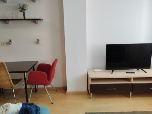 a living room with a television and a table and chairs at Estudio Céntrico D2 in Oviedo