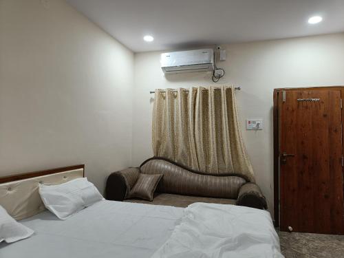 a bedroom with a bed and a chair and a window at RK RESIDENCY in Kothakota