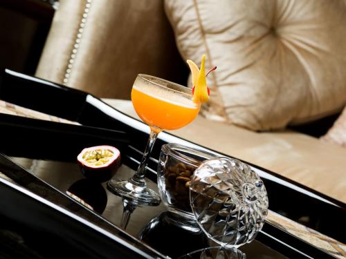 a glass of orange juice sitting on a table at Apricot Hotel in Hanoi