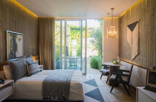 sypialnia z łóżkiem, stołem i krzesłami w obiekcie Hotel Andana Winery & Spa w mieście Valle de Guadalupe