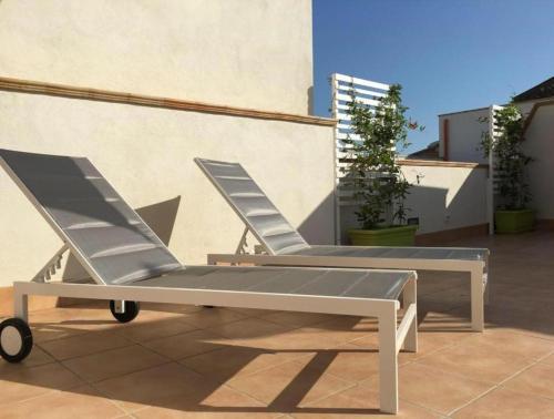 une paire de chaises longues assises sur une terrasse dans l'établissement Colibri B&B, à Sciacca