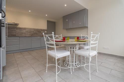 une cuisine avec une table et des chaises dans une cuisine dans l'établissement Le Pied à Terre de Montcenis - Appt avec parking privé, à Montcenis