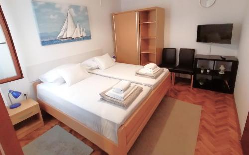 Apartments Miha في كرك: غرفة نوم صغيرة بها سرير مع قارب شراعي