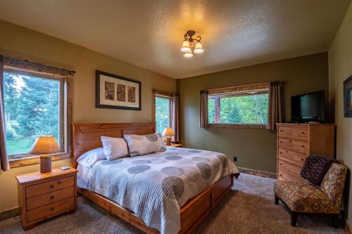 una camera con un letto e una TV e due finestre di Snow Creek Lodge a West Yellowstone