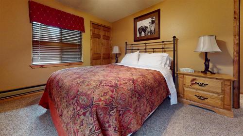 Un dormitorio con una cama grande y una ventana en Trapper Condo Unit 7 en West Yellowstone