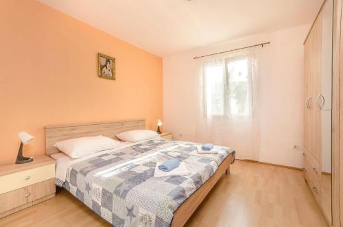 Schlafzimmer mit einem Bett und einem Fenster in der Unterkunft House Rajka I in Vodice