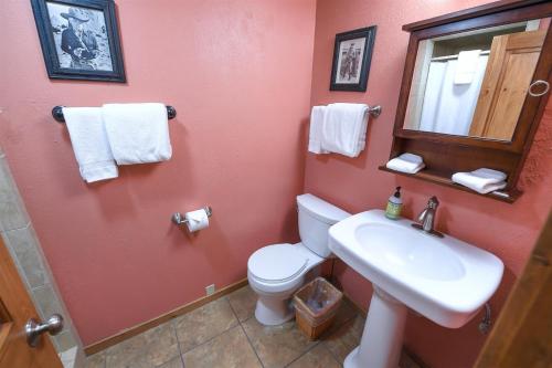 y baño con aseo, lavabo y espejo. en Trapper Condo Unit 3 en West Yellowstone