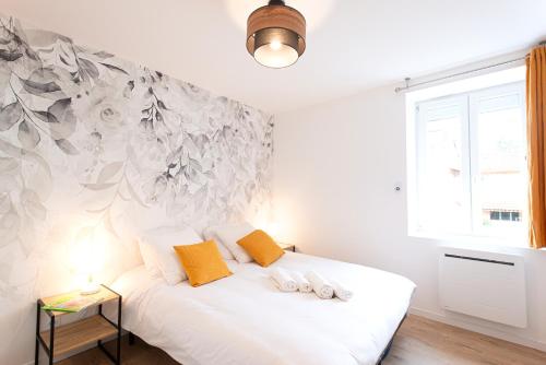 ein Schlafzimmer mit einem weißen Bett mit zwei Kissen in der Unterkunft L'Escale Ocre - 150m Restaurant 3 étoiles in Vonnas