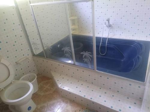 a bathroom with a blue tub with a toilet at Cabaña represa Prado 25+ huesp in Prado