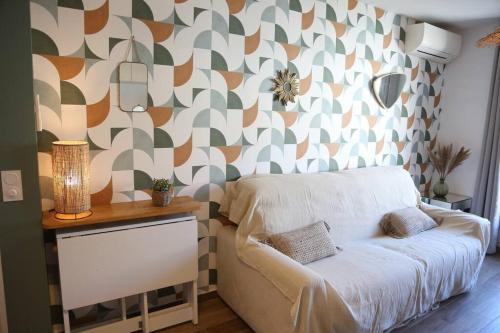 ein Schlafzimmer mit einem Sofa und einer Wand mit einem Muster in der Unterkunft Appartement Lavande YourHostHelper in Saint-Cyr-sur-Mer