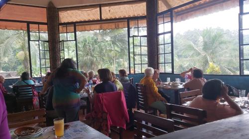 a group of people sitting at tables in a restaurant at HOSTERIA EL PARAISO in Pedro Vicente Maldonado