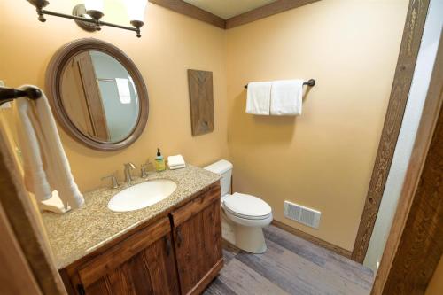 een badkamer met een wastafel, een toilet en een spiegel bij Trapper Condo Unit 5 in West Yellowstone