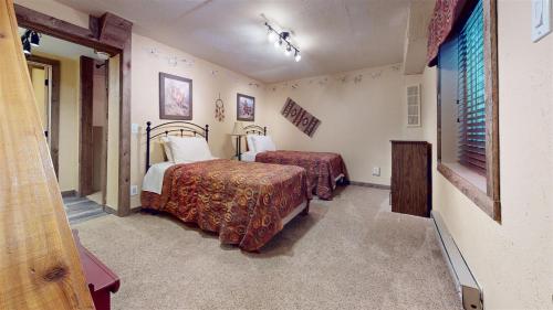 a hotel room with two beds and a television at Trapper Condo Unit 5 in West Yellowstone