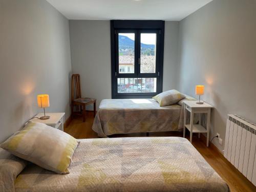 um quarto com 2 camas e uma janela em Apartamentos Montejurra em Ayegui