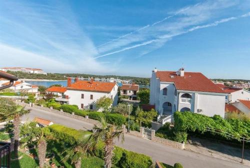 a large white house with a red roof at Apartments and Rooms Viktorija in Vinkuran