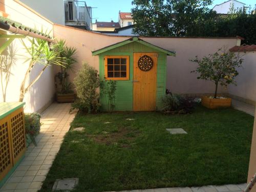 una pequeña casa verde para perros en un patio en PIANO TERRA CON GIARDINO VICINO AL MARE en Viareggio