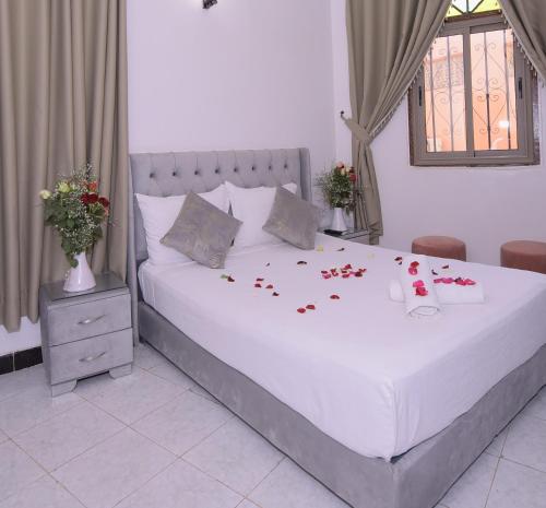 a bedroom with a bed with roses pedals on it at Hotel Riad Fantasia in Marrakech