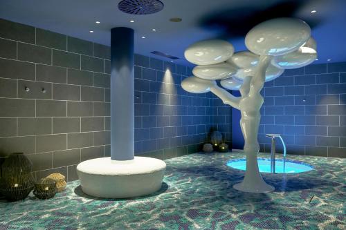 a bathroom with a sculpture of a tree on the floor at The Donna Portals in Portals Nous