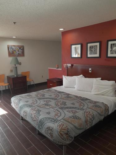ein Schlafzimmer mit einem großen Bett mit einer roten Wand in der Unterkunft Relax Inn in Franklin