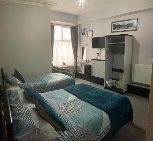 um quarto de hotel com duas camas e uma televisão em Hornby Villa 4*B&B Couples & Families Only em Blackpool