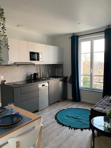 Il comprend une cuisine et un salon avec une table. dans l'établissement VILLA GABI, à Juvisy-sur-Orge