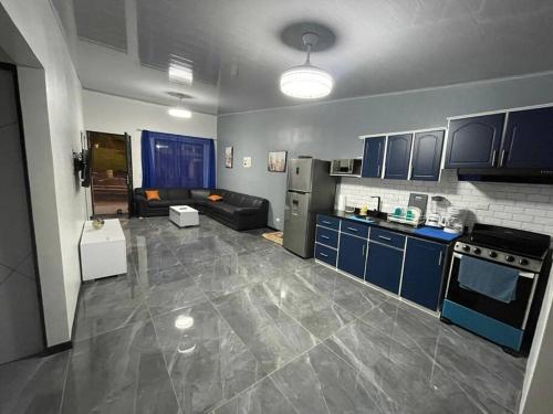 a kitchen and living room with blue cabinets and a couch at Jaco Beach Villa Arenas Condo in Jacó
