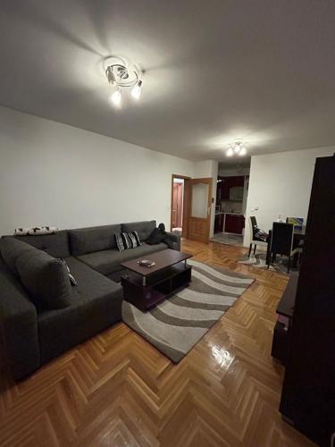 uma sala de estar com um sofá e uma mesa em Apartman SARA em Sarajevo