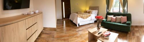 a living room with a bed and a couch at loft grupo y parejas AZUCENAS in Jardin