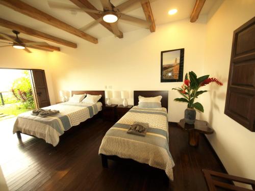 a room with two beds in a room at Hacienda Las Vainillas Boutique Hotel in Mastatal