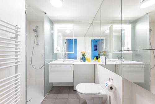 a white bathroom with a toilet and a shower at HM • New Studio by WU & Messe in Vienna