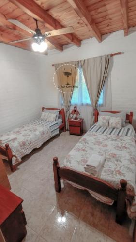 Malbec Departamentos في مايبو: غرفة نوم بسريرين وسقف