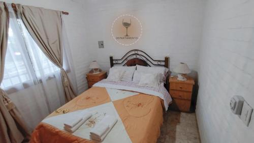 Malbec Departamentos في مايبو: غرفة نوم مع سرير مع مواقف ليلتين ونافذة
