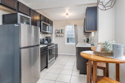 a kitchen with a stainless steel refrigerator and a table at Charm City Hideout 2bdr and Basement in Indianapolis