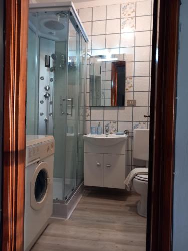 y baño con lavamanos y lavadora. en Dai Biancot, en Camagna Monferrato
