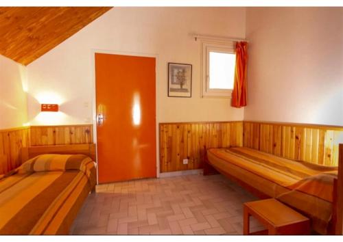 a bedroom with two beds and a window at Le village de Sèchemailles in Ambrugeat