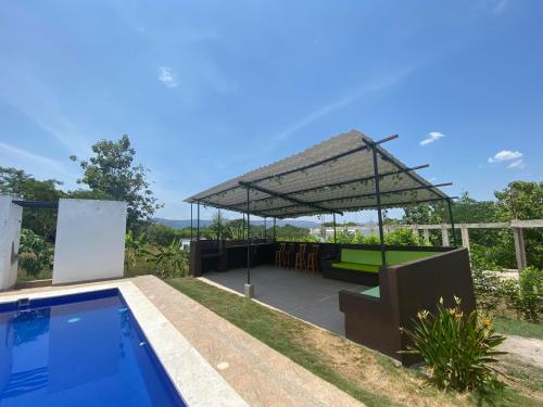 a pavilion with a pool and a picnic table at Villa con piscina privada y zona bbq en condominio in Carmen de Apicalá