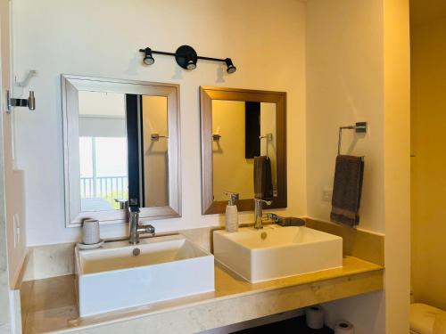 La salle de bains est pourvue de 2 lavabos et d'un grand miroir. dans l'établissement Holiday apartment at La Diosa condos Isla Mujeres, à Isla Mujeres
