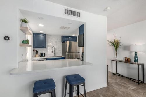 a kitchen with a white counter and blue stools at Blue Abode - Old Town Scottsdale - Pool &BBQ Grill in Scottsdale