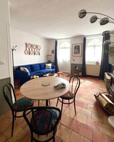 een woonkamer met een tafel en stoelen bij Charmante Maisonette à Arçonnay (72) in Arçonnay